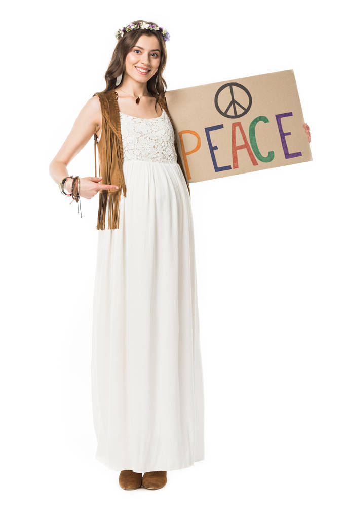 full length view of pregnant hippie woman pointing with finger at placard with inscription isolated on white - Photo, Image