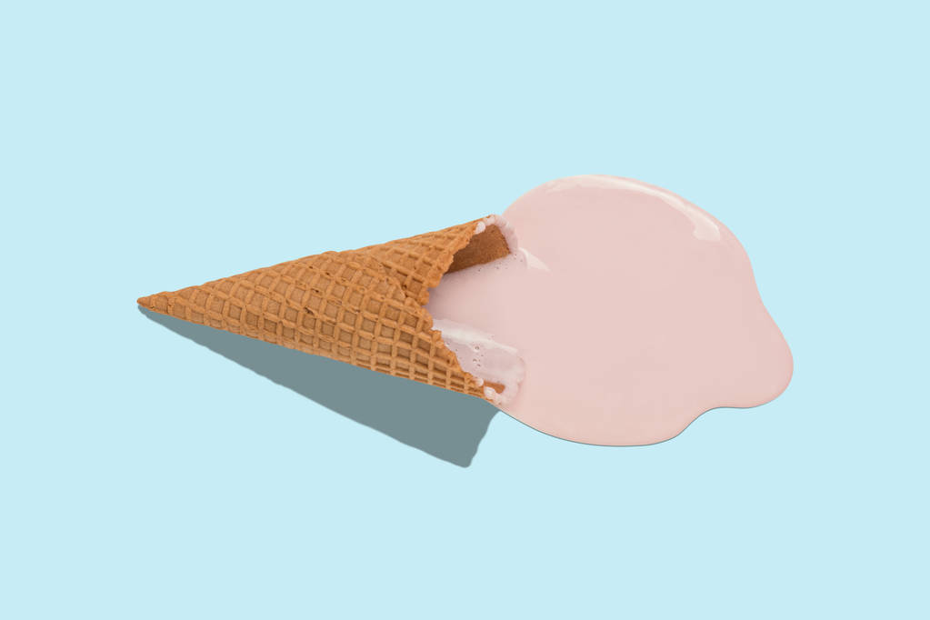 Helado derretido con cono de helado sobre fondo azul pastel. Concepto mínimo de comida de verano
.  - Foto, imagen