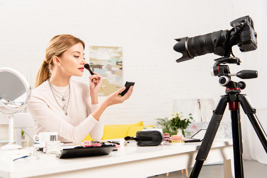 Beauty-Bloggerin trägt Gesichtspuder vor Videokamera auf - Foto, Bild