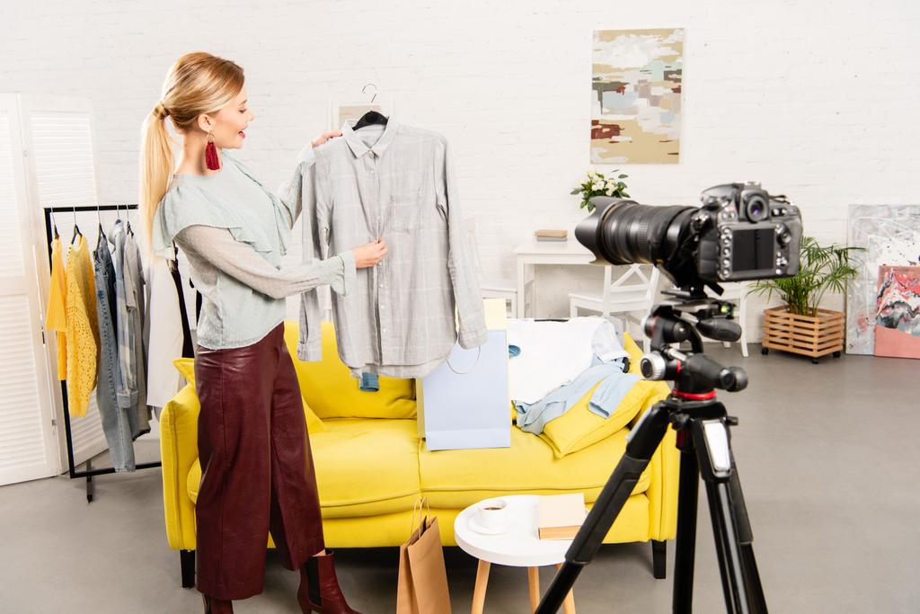 usmívající se blogger zobrazující šaty před videokamerou doma - Fotografie, Obrázek