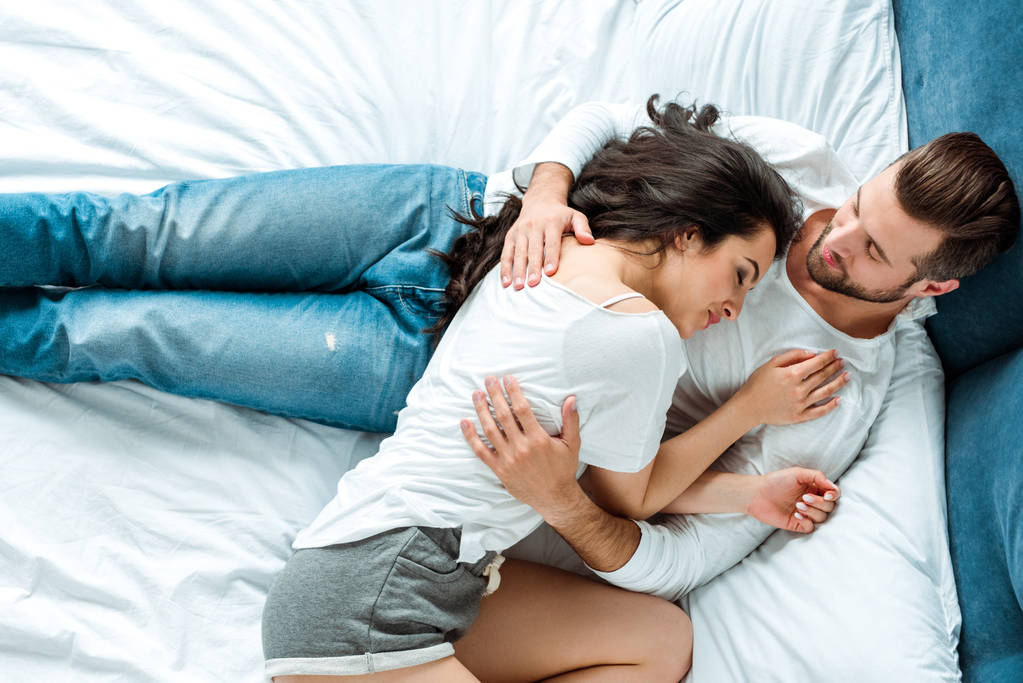 top view of girlfriend sleeping near gentle boyfriend in bed - Photo, Image