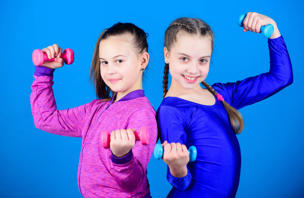 Dieta fitness para la salud energética. tríceps entrenamiento de las niñas pequeñas sostienen mancuerna. Éxito deportivo. levantamiento de pesas para músculos. Deportista de niños felices con barra. ejercicio de tríceps. tricepsworkout
 - Foto, imagen