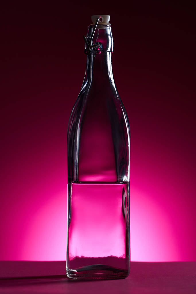 transparent bottle with water on pink background with back light - Photo, Image