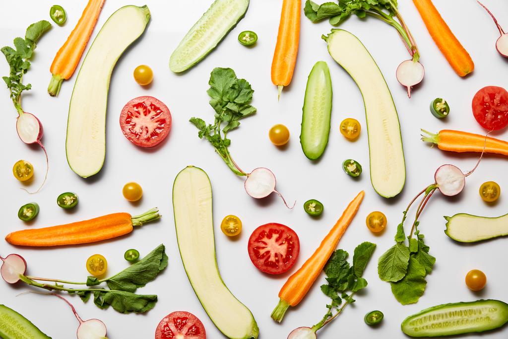 Draufsicht auf frisches geschnittenes Gemüse auf weißem Hintergrund - Foto, Bild