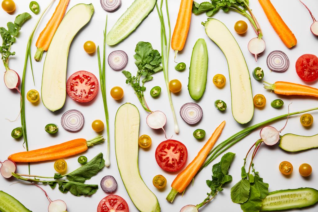 Beyaz arka planda taze dilimlenmiş besleyici sebzelerin üst görünümü - Fotoğraf, Görsel