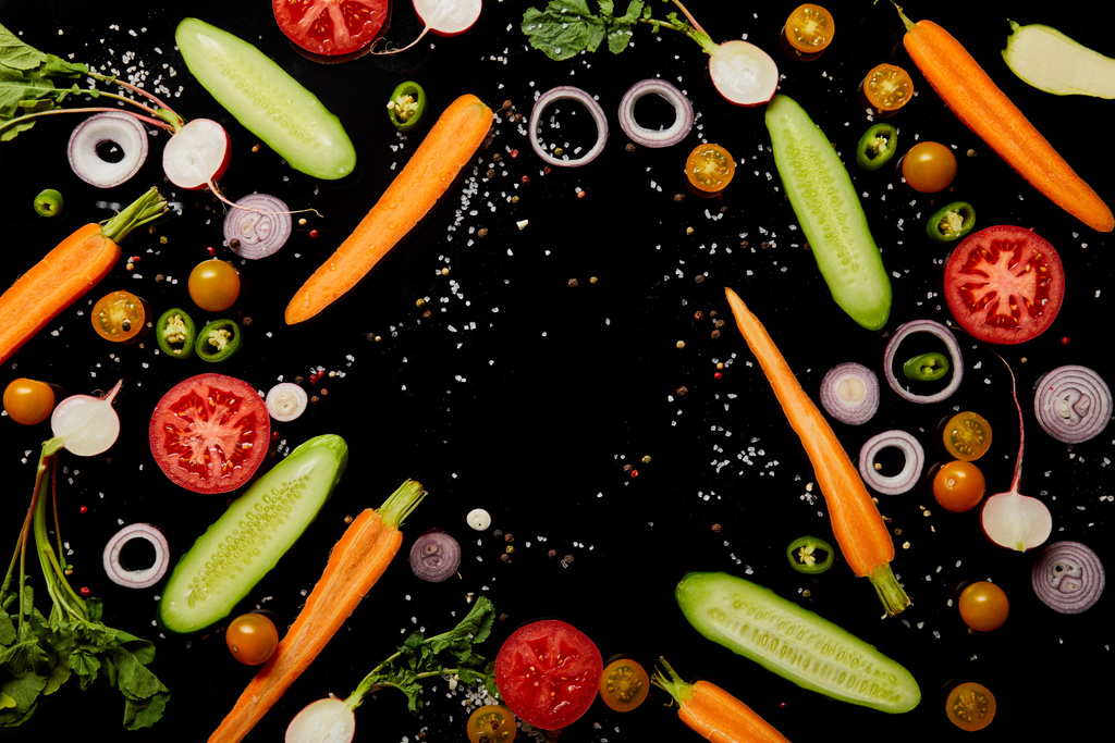 вид сверху на свежие разбросанные овощные ломтики с солью, изолированной на черном
 - Фото, изображение