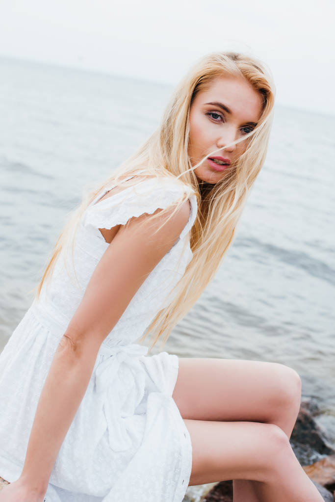přitažlivá blondýnka mladá žena v bílých šatech s fotoaparátem  - Fotografie, Obrázek