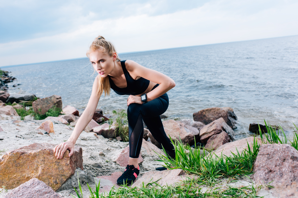 atraente loira esportista em sportswear escalada perto do mar
 - Foto, Imagem