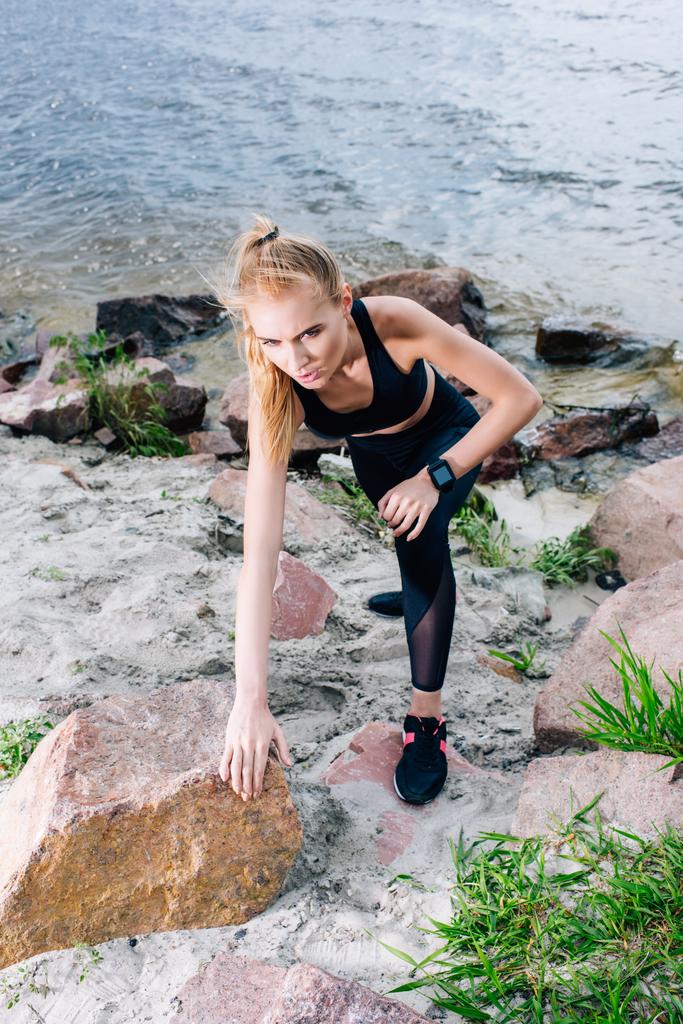 stropní pohled na atraktivní blondýnku v sportovní lezení u kamenů  - Fotografie, Obrázek