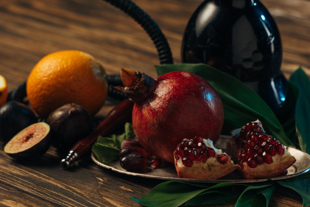 valikoiva painopiste tuoreita hedelmiä ja vesipiippu puupinnalla
 - Valokuva, kuva