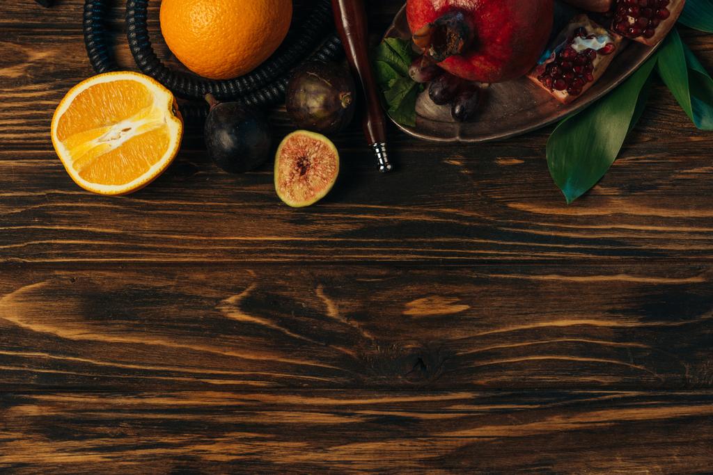 pohled na čerstvé exotické ovoce a vodní dýmka na dřevěném povrchu - Fotografie, Obrázek