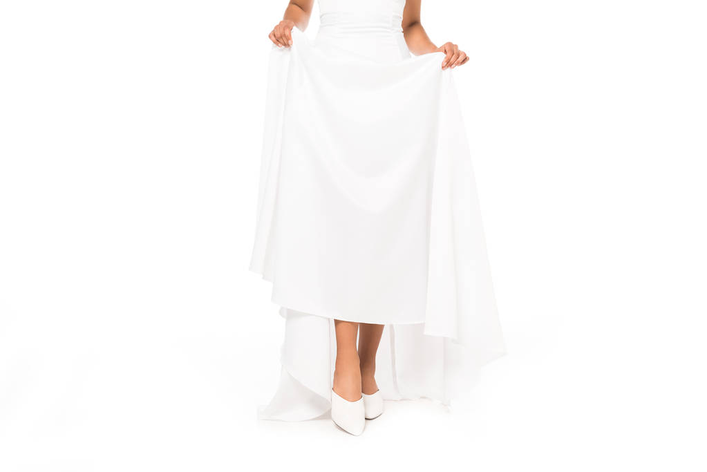 abgeschnittene Ansicht der afrikanisch-amerikanischen Braut Berührung Hochzeitskleid isoliert auf weiß  - Foto, Bild
