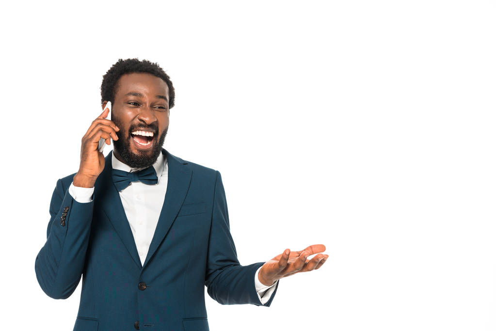 ευτυχισμένος Αφρικανός Αμερικανός Νυμφίος μιλάει σε smartphone απομονωθεί σε λευκό  - Φωτογραφία, εικόνα