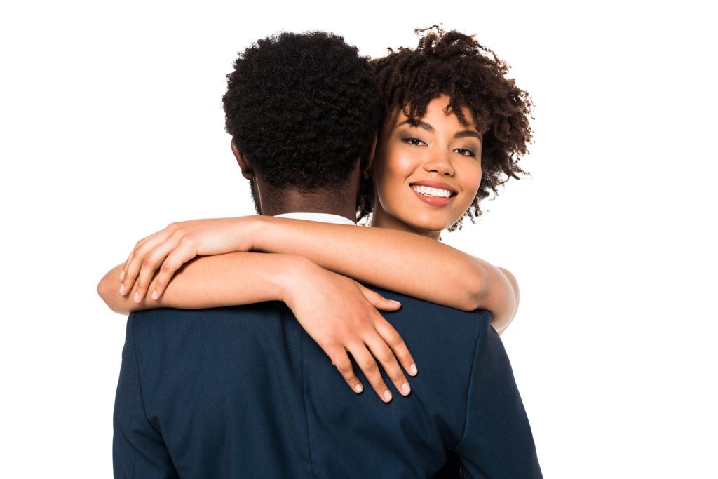 attraente e sorridente donna africana americana abbracciare l'uomo isolato su bianco
  - Foto, immagini