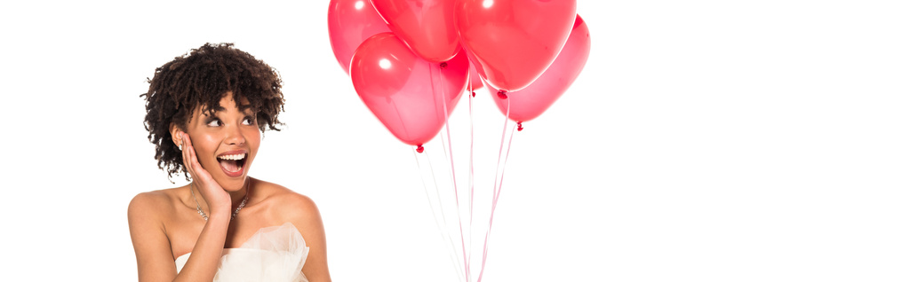tiro panorâmico de noiva americana africana animado olhando para balões rosa isolado em branco
  - Foto, Imagem
