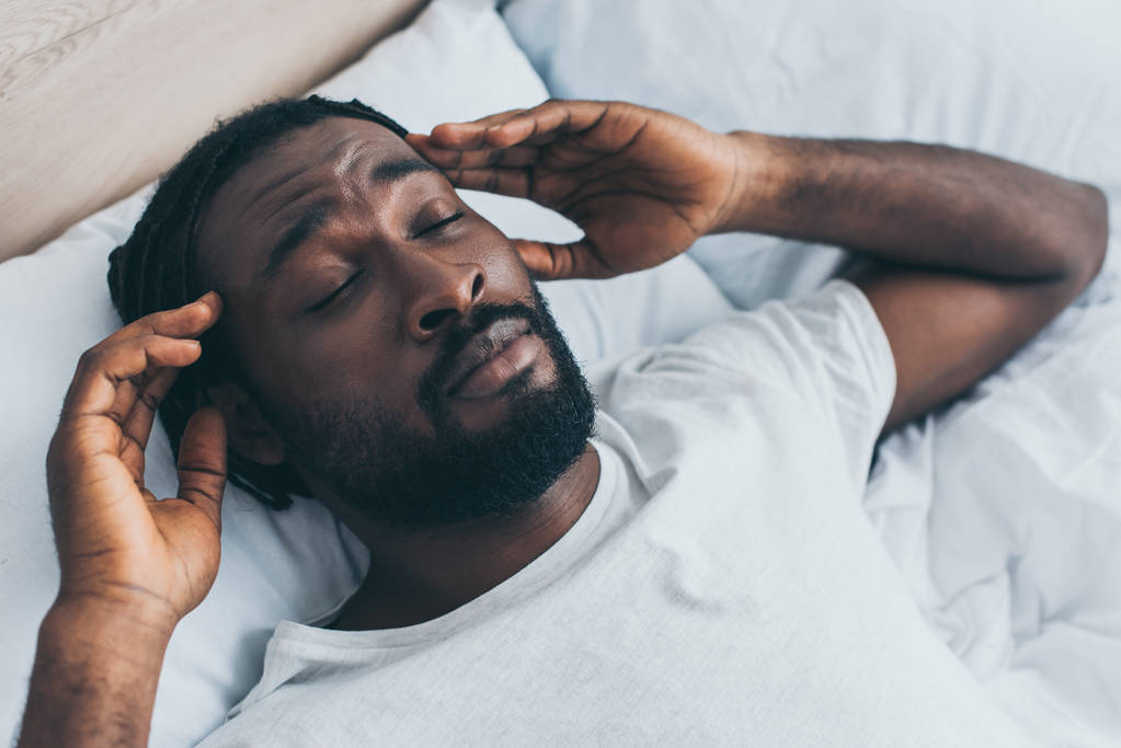 guapo afroamericano hombre que sufre de dolor de cabeza con los ojos cerrados
 - Foto, Imagen