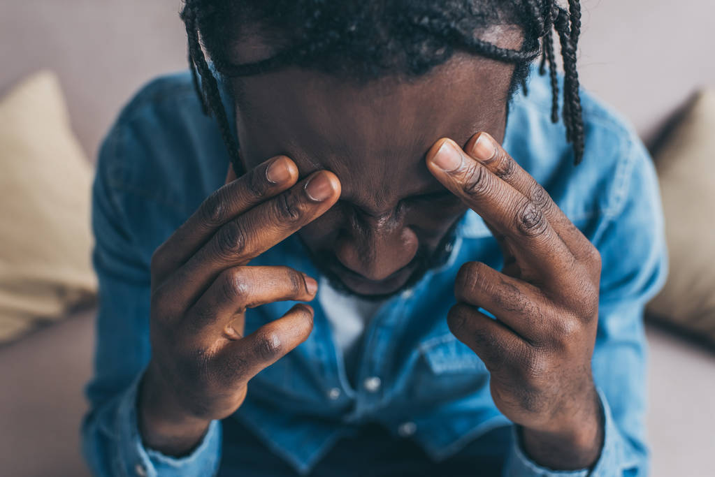 yleisnäkymä afrikkalainen amerikkalainen mies kädestä lähellä pään kärsiessään päänsärky
 - Valokuva, kuva