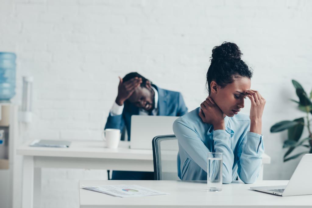 gerentes afroamericanos sentados en los lugares de trabajo y sufriendo de dolores de cabeza
 - Foto, imagen