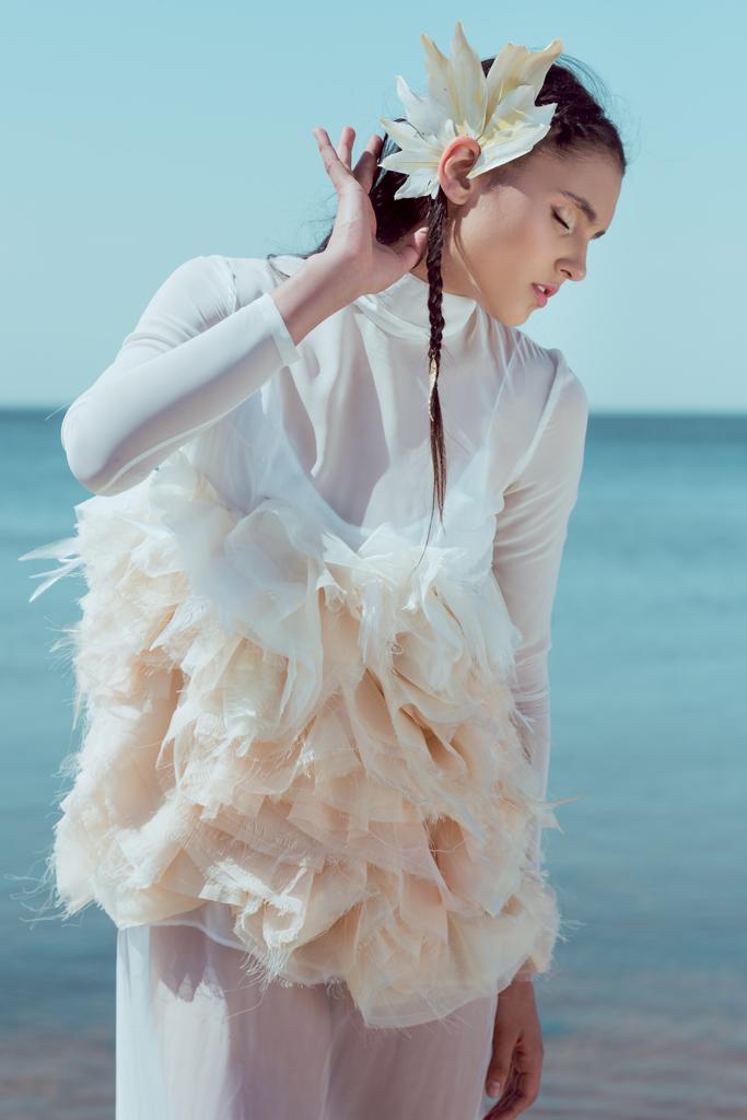 bela mulher em branco cisne traje fechar os olhos, de pé no rio azul e céu fundo
 - Foto, Imagem