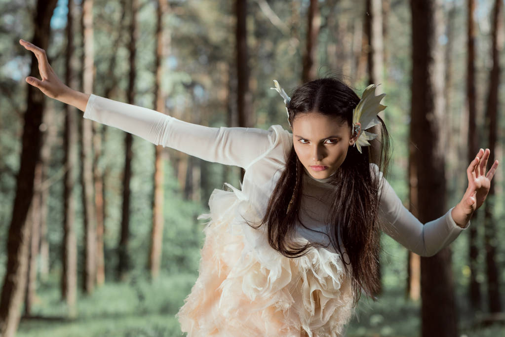 young woman in white swan costume looking away, standing in forest - Photo, Image