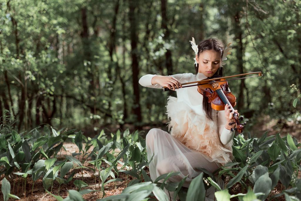 красивая женщина в белом лебедином костюме играет на скрипке
 - Фото, изображение