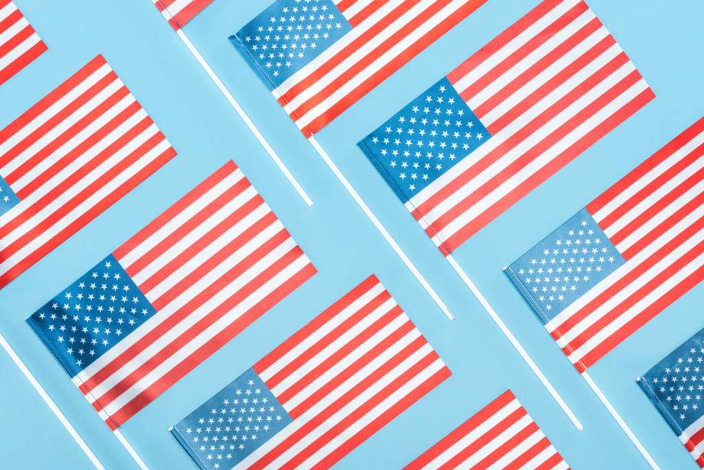 lapos feküdt a nemzeti amerikai zászlók a botok kék háttér - Fotó, kép