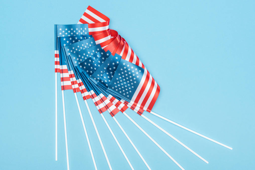 vue du dessus des drapeaux américains sur bâtons sur fond bleu
 - Photo, image