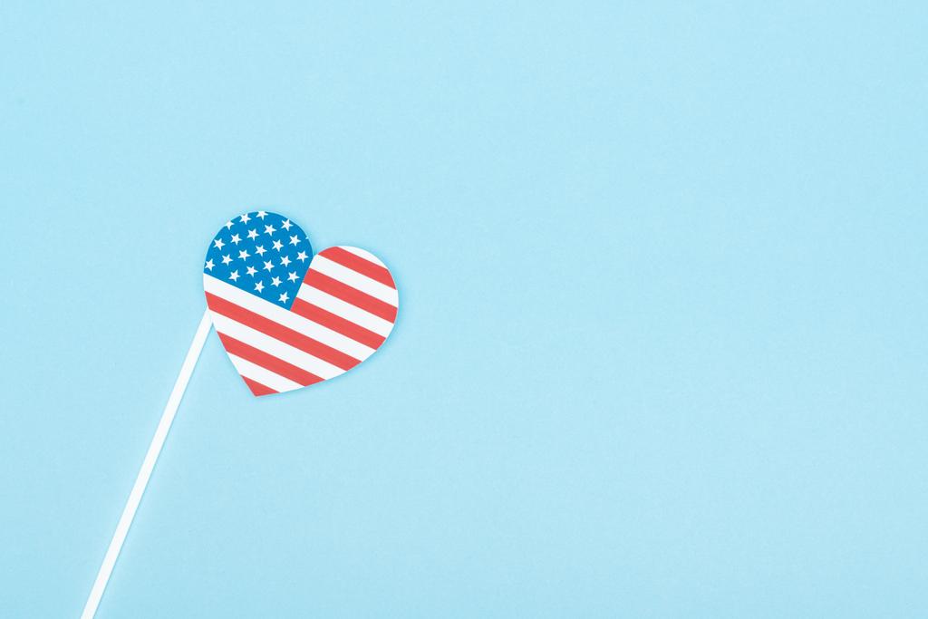 コピースペースと青い背景にアメリカの旗で作られた紙カット装飾ハートのトップビュー - 写真・画像