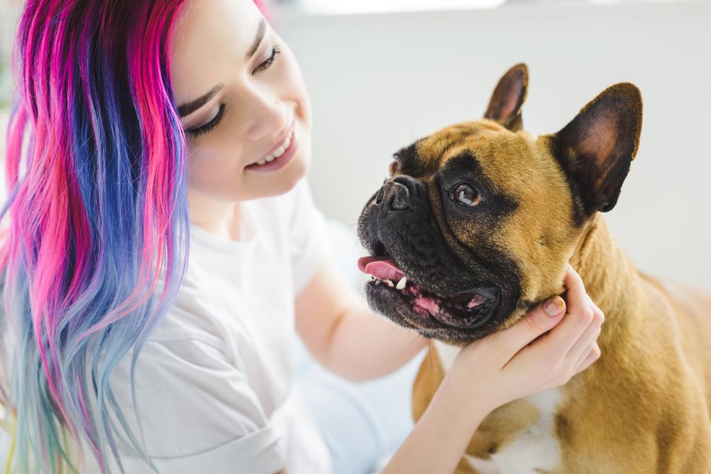 menina atraente com carinho de cabelo colorido e olhando para bulldog francês bonito
  - Foto, Imagem