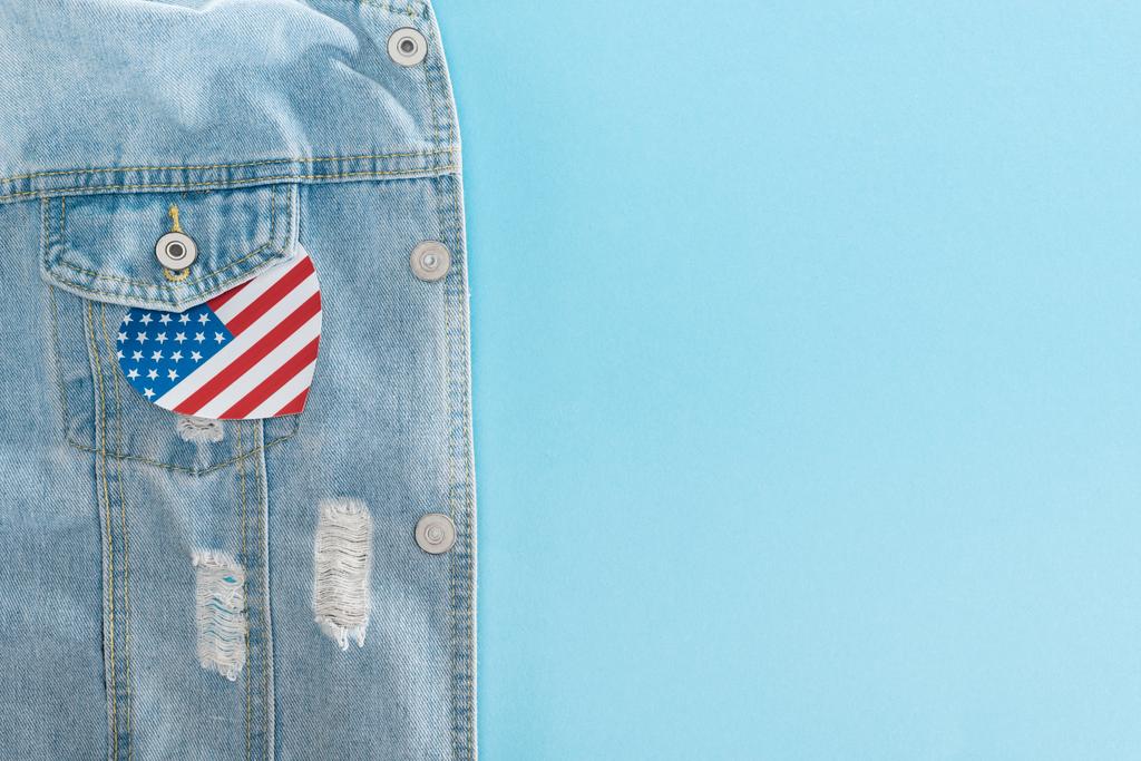 vista dall'alto del cuore tagliato di carta fatto di bandiera americana su giacca di jeans su sfondo blu con spazio copia
 - Foto, immagini