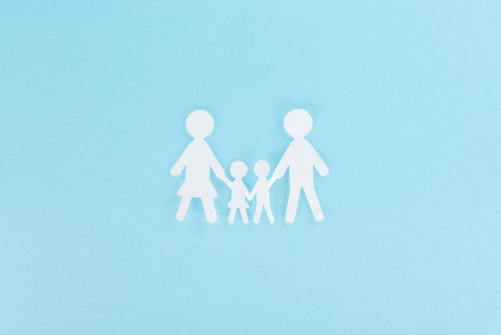 вид зверху на різану сім'ю з білого паперу на синьому фоні
  - Фото, зображення