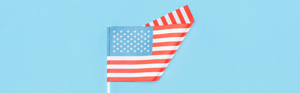 вид сверху на американский флаг на палочке на синем фоне, панорамный снимок
  - Фото, изображение