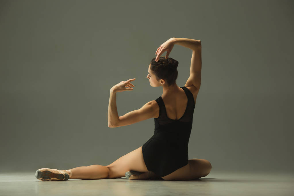 Νεαρή χαριτωμένη χορεύτρια μπαλέτου που χορεύει στο μικτό φως - Φωτογραφία, εικόνα