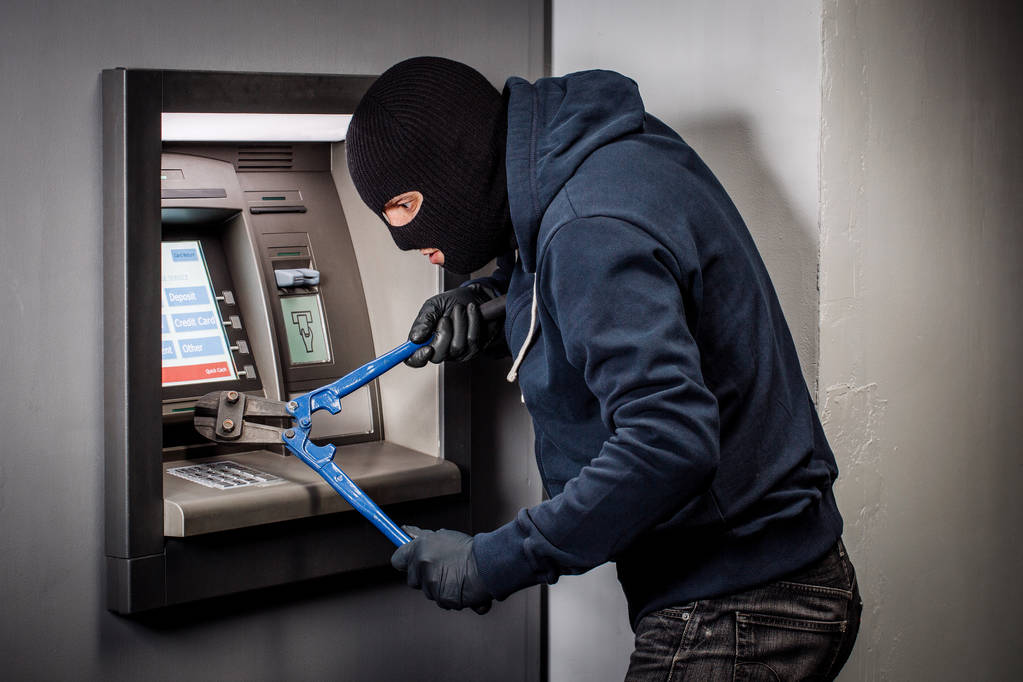 Thief with bolt cutter hacks an ATM. Law and crime concept - Photo, Image