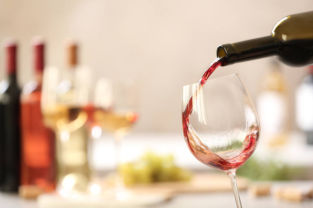 Na rozmazané pozadí nalijete červené víno z láhve do skla. Místo pro text - Fotografie, Obrázek