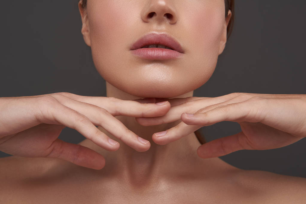 Beautiful young woman with perfect skin keeping hands under her chin - Photo, Image