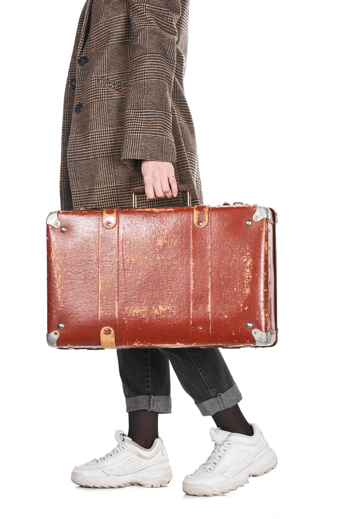 vista ritagliata di donna in cappotto a quadri che cammina con valigia vintage intemperie isolata su bianco
 - Foto, immagini
