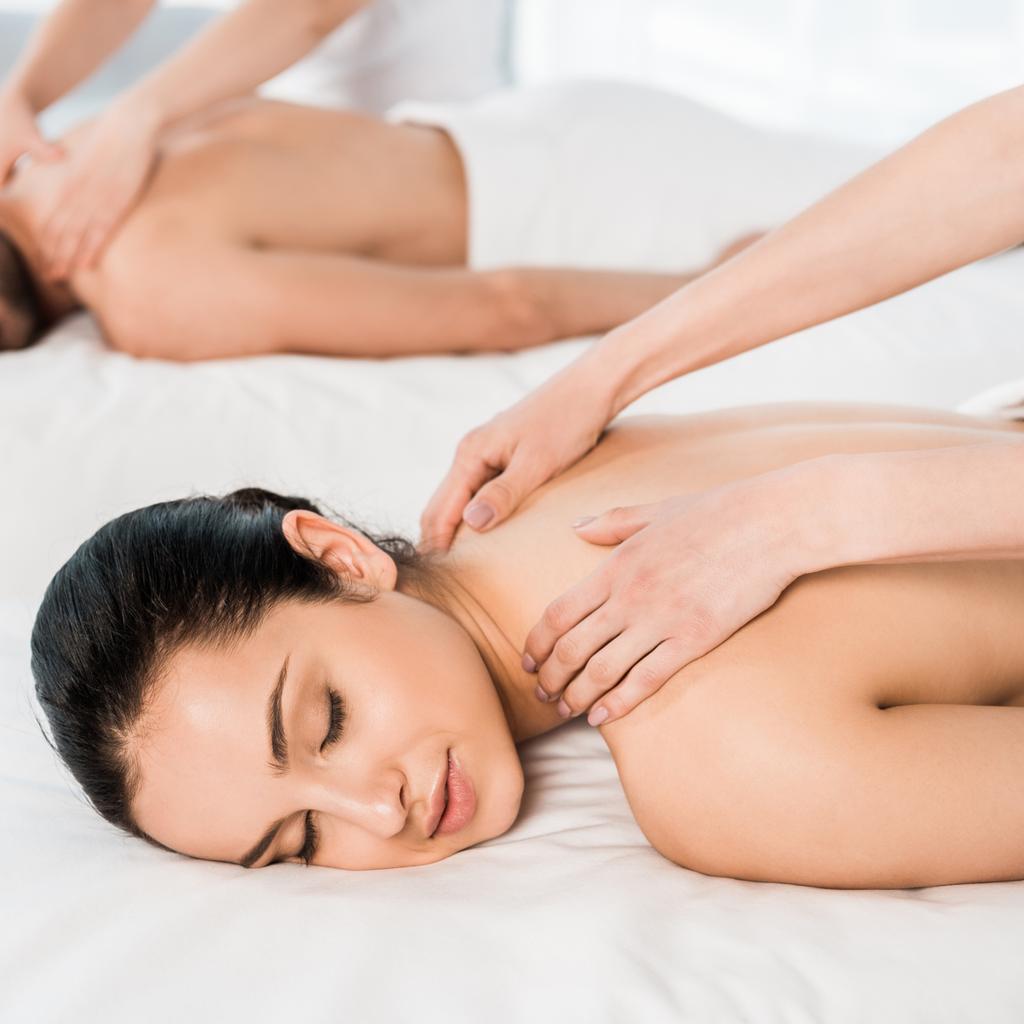 foyer sélectif de masseur faisant massage à la femme attrayante avec les yeux fermés près de l'homme
  - Photo, image