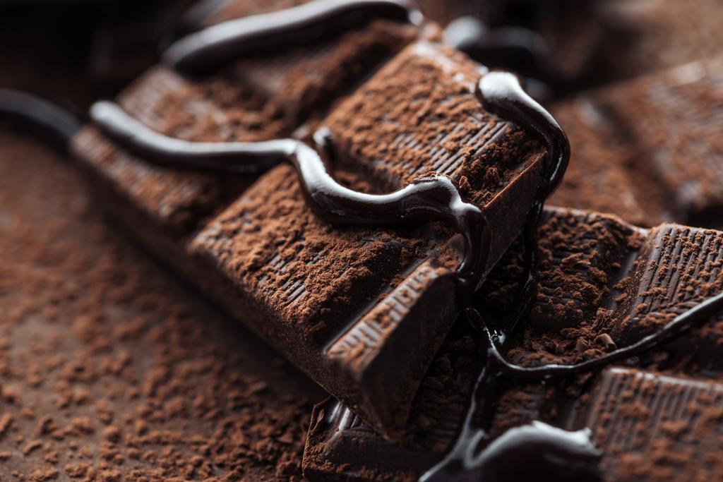 液体チョコレートとココアパウダーとダークチョコレートバーの作品のクローズアップビュー - 写真・画像