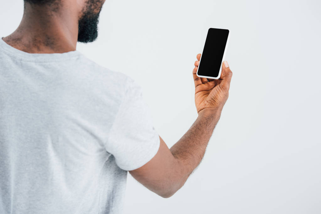 περικομμένη όψη του Αφρικανού αμερικανικού ανθρώπου χρησιμοποιώντας smartphone με κενή οθόνη, απομονώνεται σε γκρι - Φωτογραφία, εικόνα