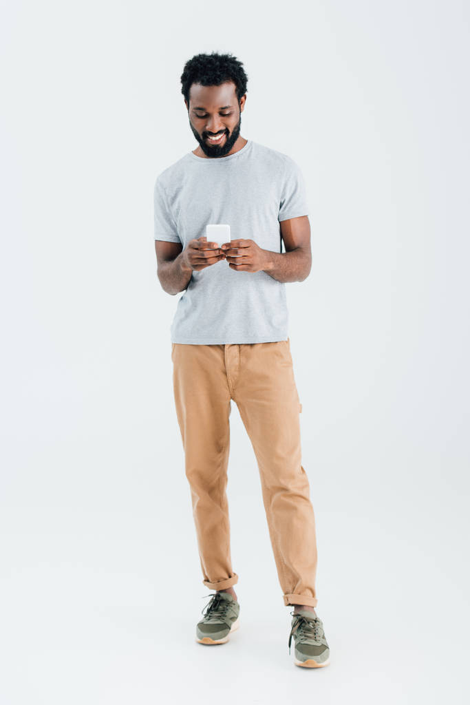 szczęśliwy African American Man za pomocą smartfona, izolowane na szarym - Zdjęcie, obraz