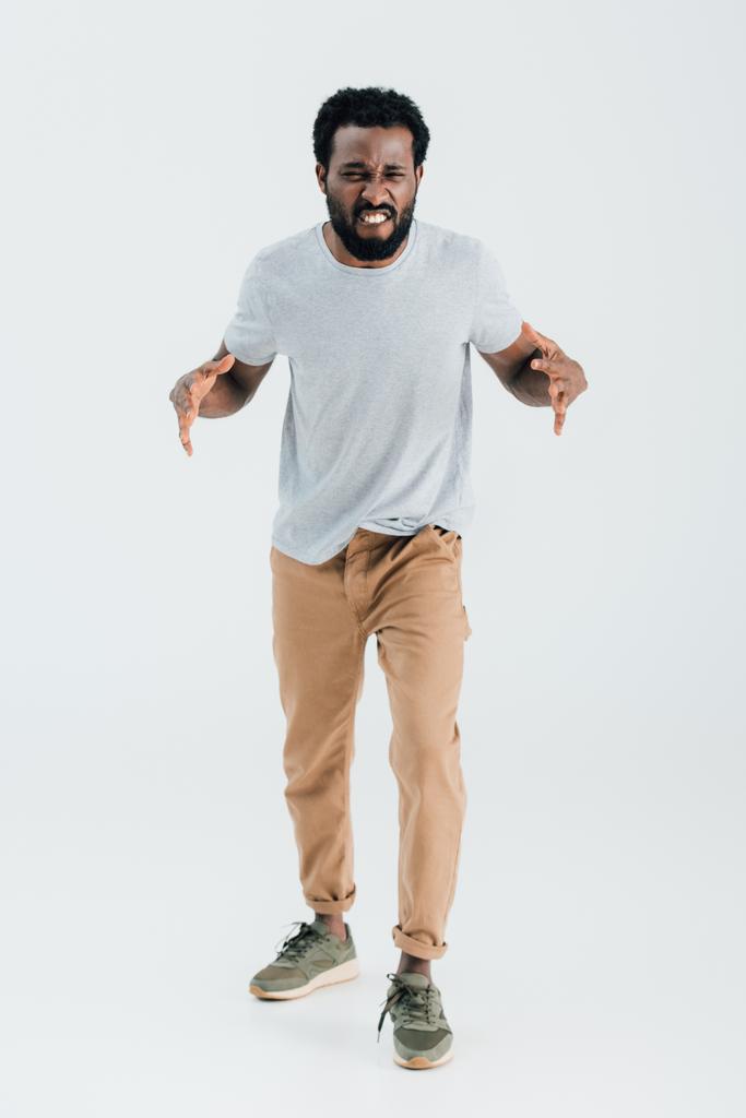 aggressiver afrikanisch-amerikanischer Mann in grauem T-Shirt posiert isoliert auf grau - Foto, Bild