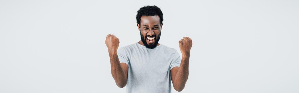 erfolgreicher afrikanisch-amerikanischer Mann im grauen T-Shirt gestikuliert isoliert auf grau - Foto, Bild