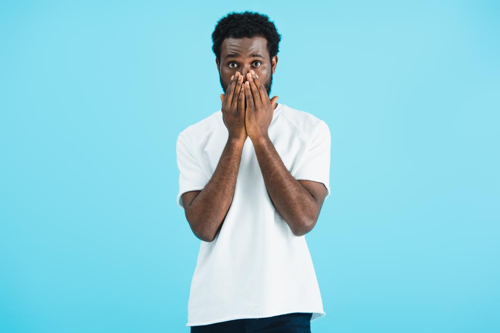 розчарований афроамериканський чоловік у білій футболці закриття обличчя, ізольований на синьому
   - Фото, зображення