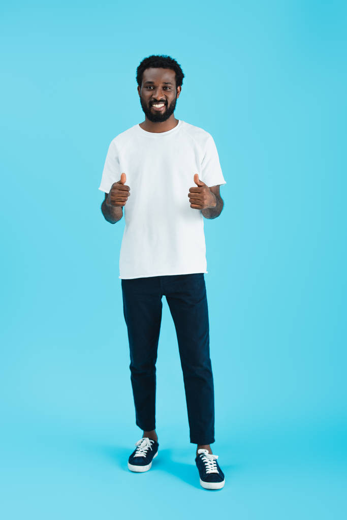 sorridente afro-americano homem mostrando polegares para cima isolado em azul
 - Foto, Imagem