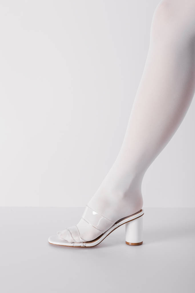 vue recadrée de la jeune femme à la mode posant dans la chaussure sur blanc
  - Photo, image