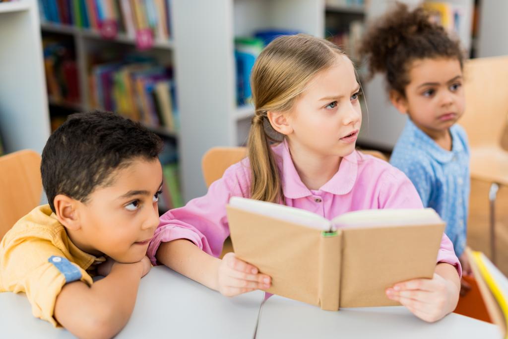 foyer sélectif d'enfant tenant livre près des enfants afro-américains
  - Photo, image
