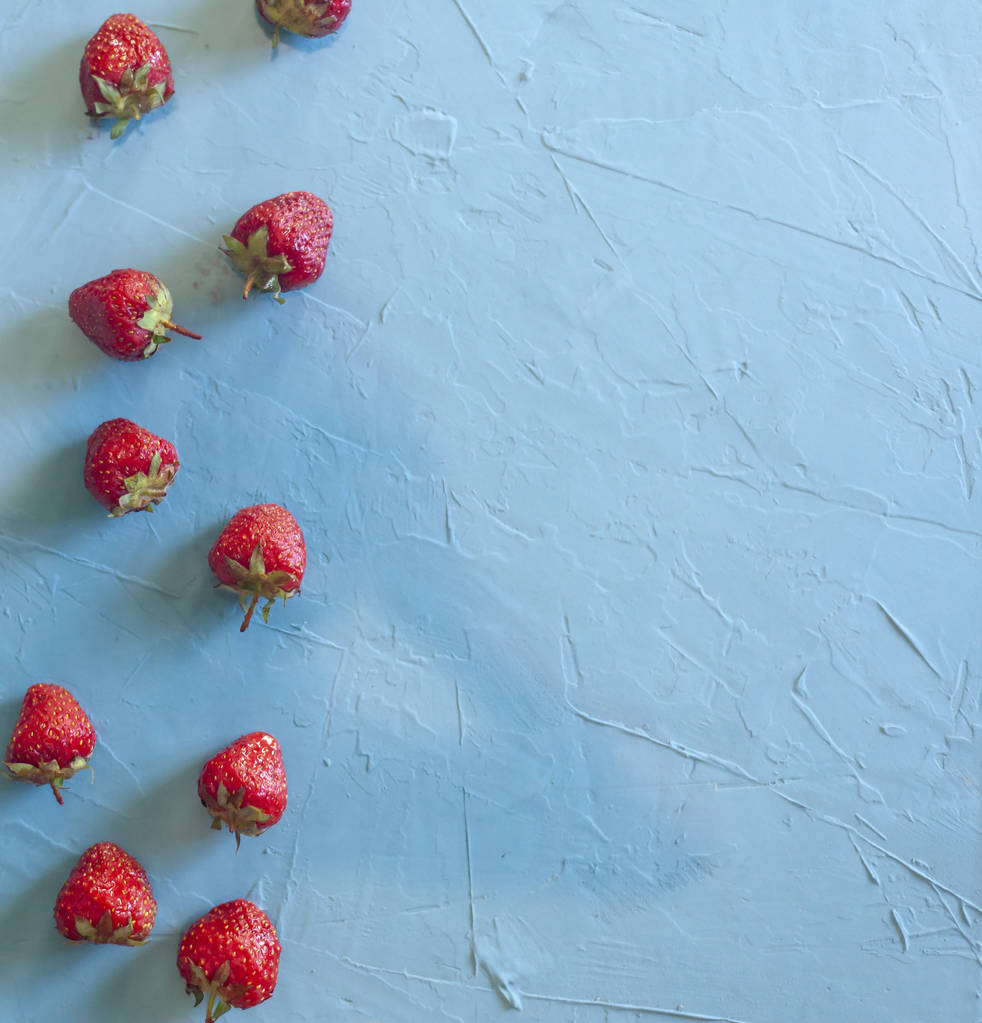 Pile of strawberries on bright blue background - Photo, Image