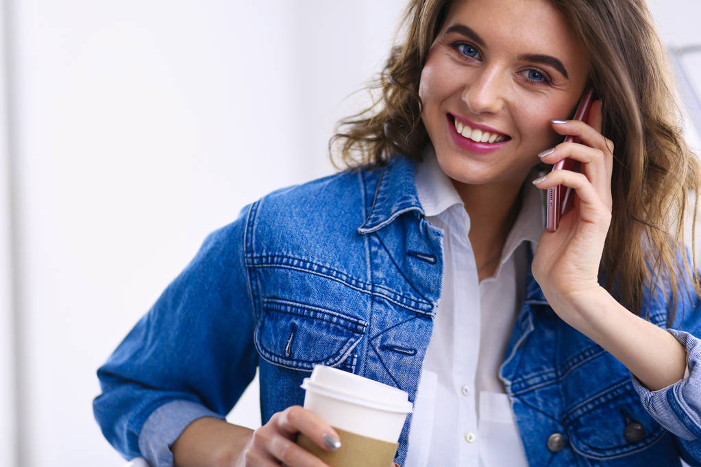 Νεαρή επιχειρηματίας μιλάει στο τηλέφωνο στην καφετέρια - Φωτογραφία, εικόνα