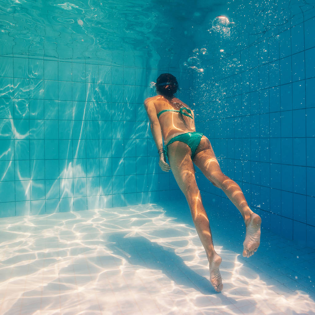 vista subacquea della donna che indossa bikini verde nuotare in piscina
 - Foto, immagini